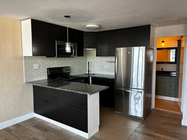a kitchen with stainless steel appliances granite countertop a refrigerator and a stove top oven