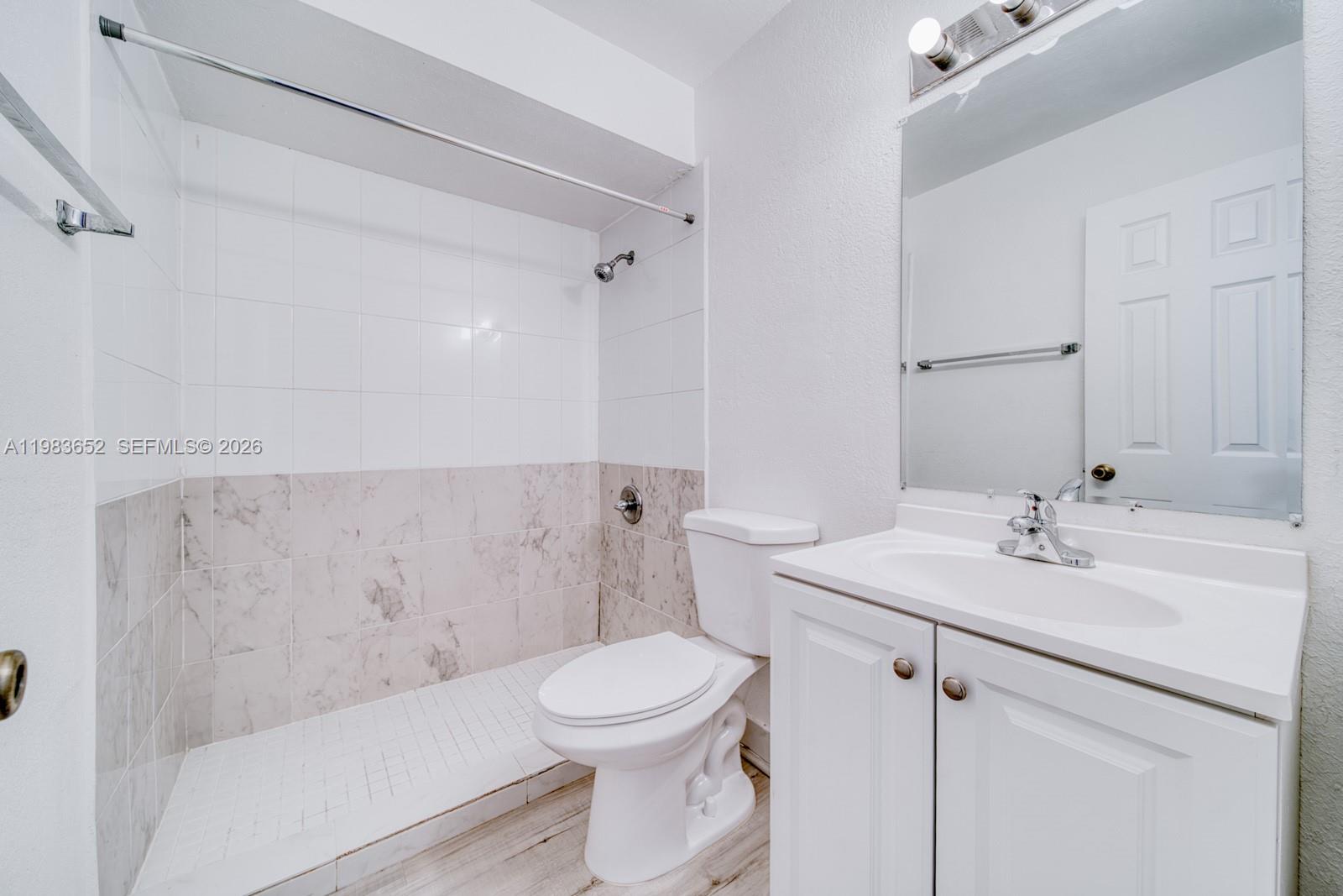 9459 Southwest 76th Street, Unit R5 Miami, FL 33173 - Photo 3 of 33 a bathroom with a sink a toilet and a mirror
