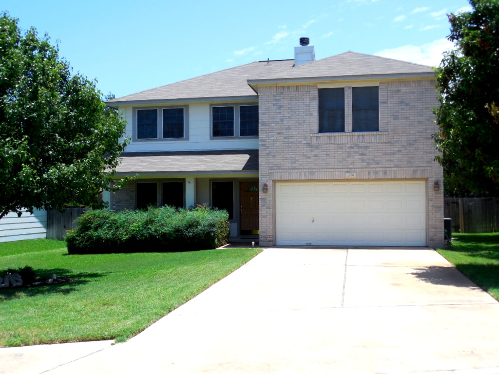 a front view of a house with a yard and trees