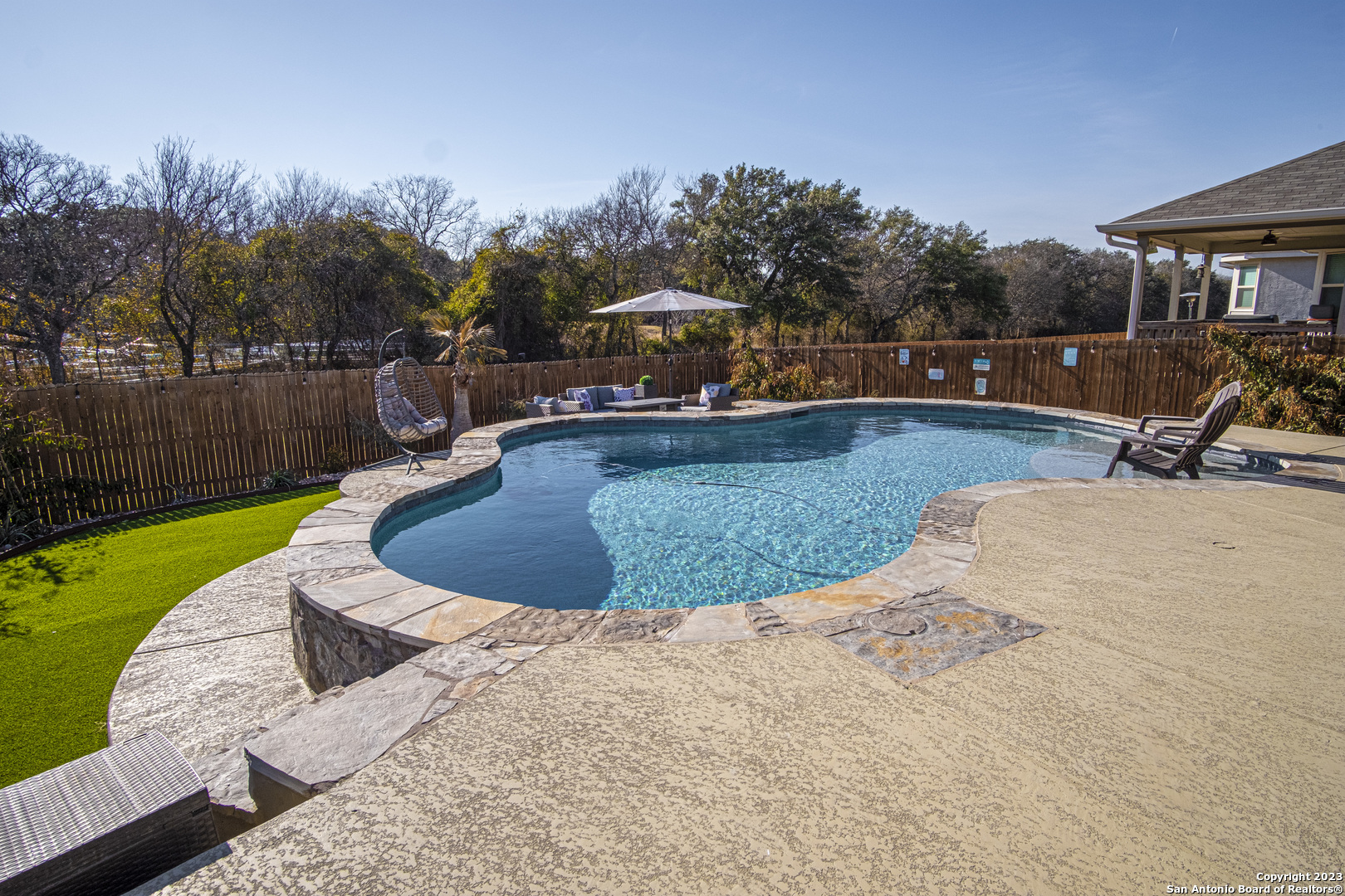 a view of a swimming pool with a yard and sitting area