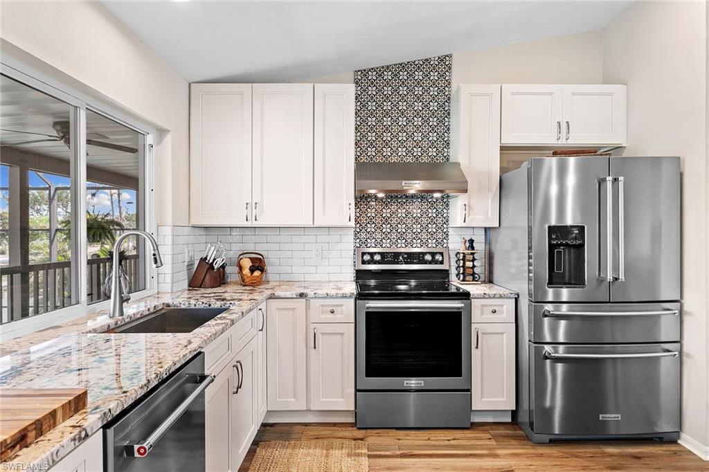 21531 Madera Road Fort Myers Beach, FL 33931 - Photo 11 of 49 a kitchen with granite countertop a refrigerator stove and sink