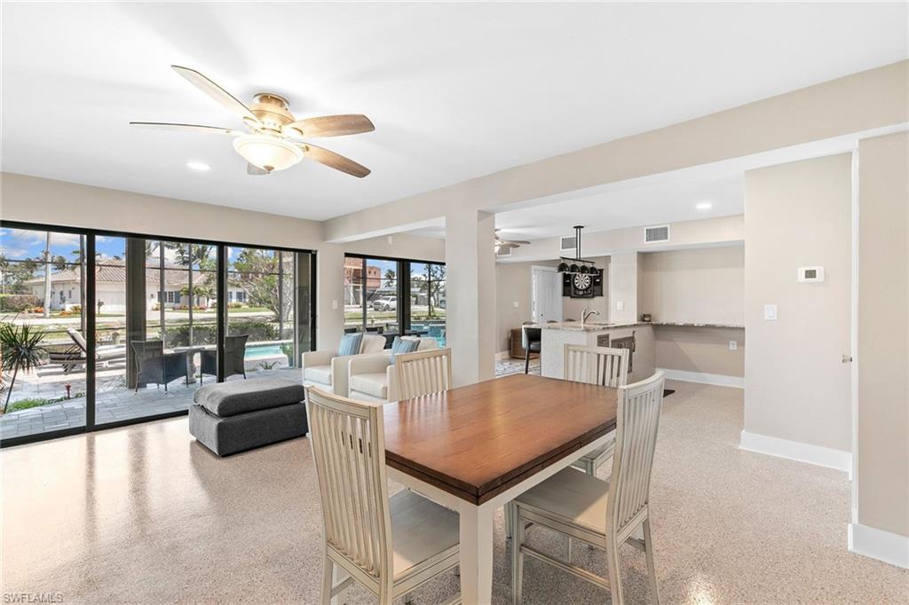 21531 Madera Road Fort Myers Beach, FL 33931 - Photo 23 of 49 a view of a dining room with furniture large windows and wooden floor
