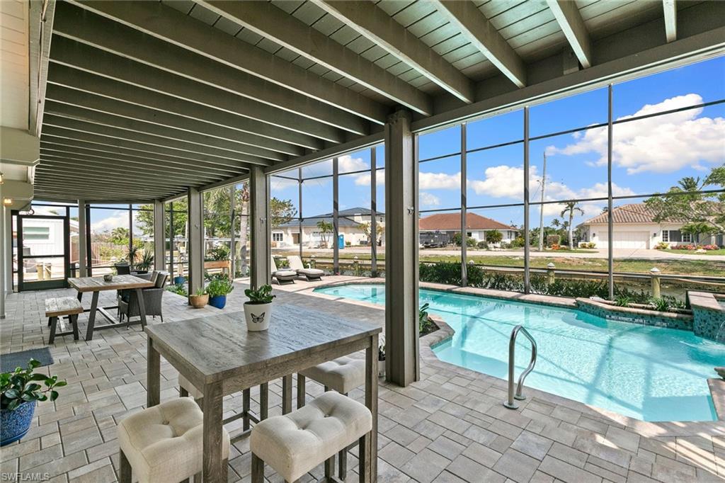 21531 Madera Road Fort Myers Beach, FL 33931 - Photo 27 of 49 a dining room with furniture and a floor to ceiling window