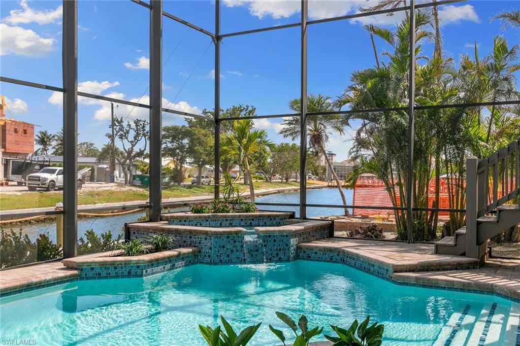 21531 Madera Road Fort Myers Beach, FL 33931 - Photo 33 of 49 a view of a swimming pool with lawn chairs under an umbrella