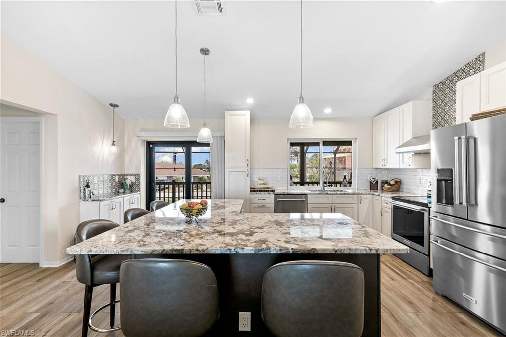 21531 Madera Road Fort Myers Beach, FL 33931 - Photo 8 of 49 a kitchen with granite countertop kitchen island stainless steel appliances a sink stove and refrigerator