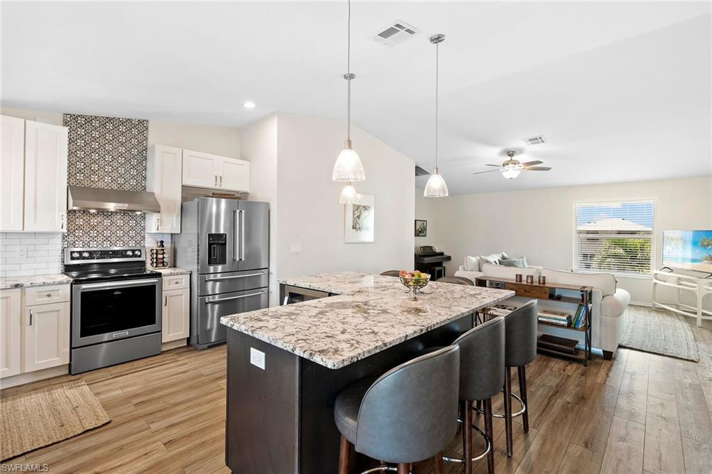 21531 Madera Road Fort Myers Beach, FL 33931 - Photo 9 of 49 a kitchen with a stove a refrigerator and wooden floor
