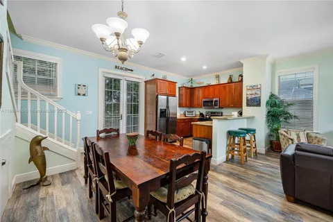 a kitchen with stainless steel appliances kitchen island granite countertop a stove a sink dishwasher a dining table and chairs with wooden floor