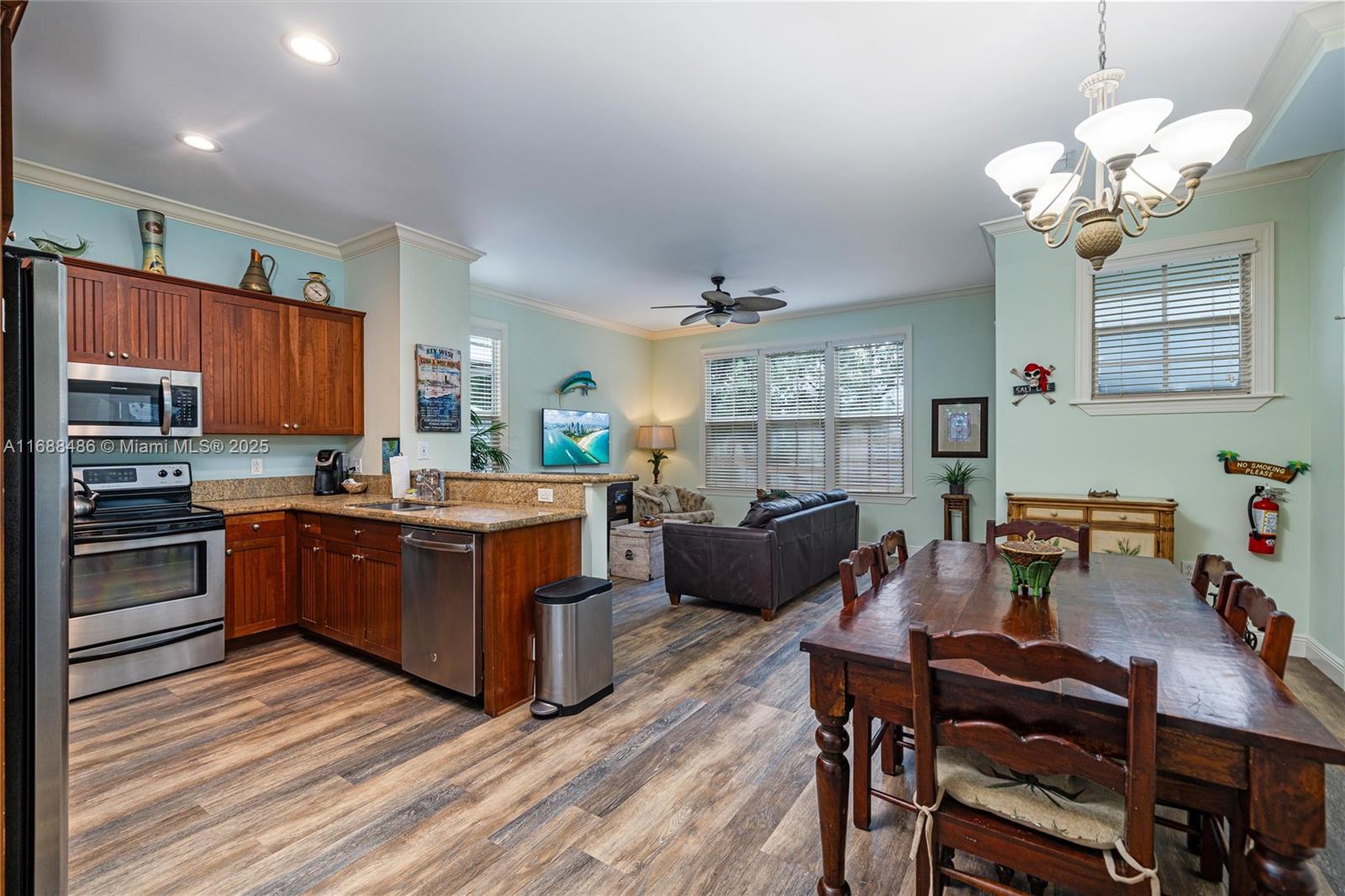 120 Anglers Way Islamorada, FL 33036 - Photo 10 of 36 a kitchen with stainless steel appliances kitchen island granite countertop a stove a sink dishwasher a dining table and chairs with wooden floor