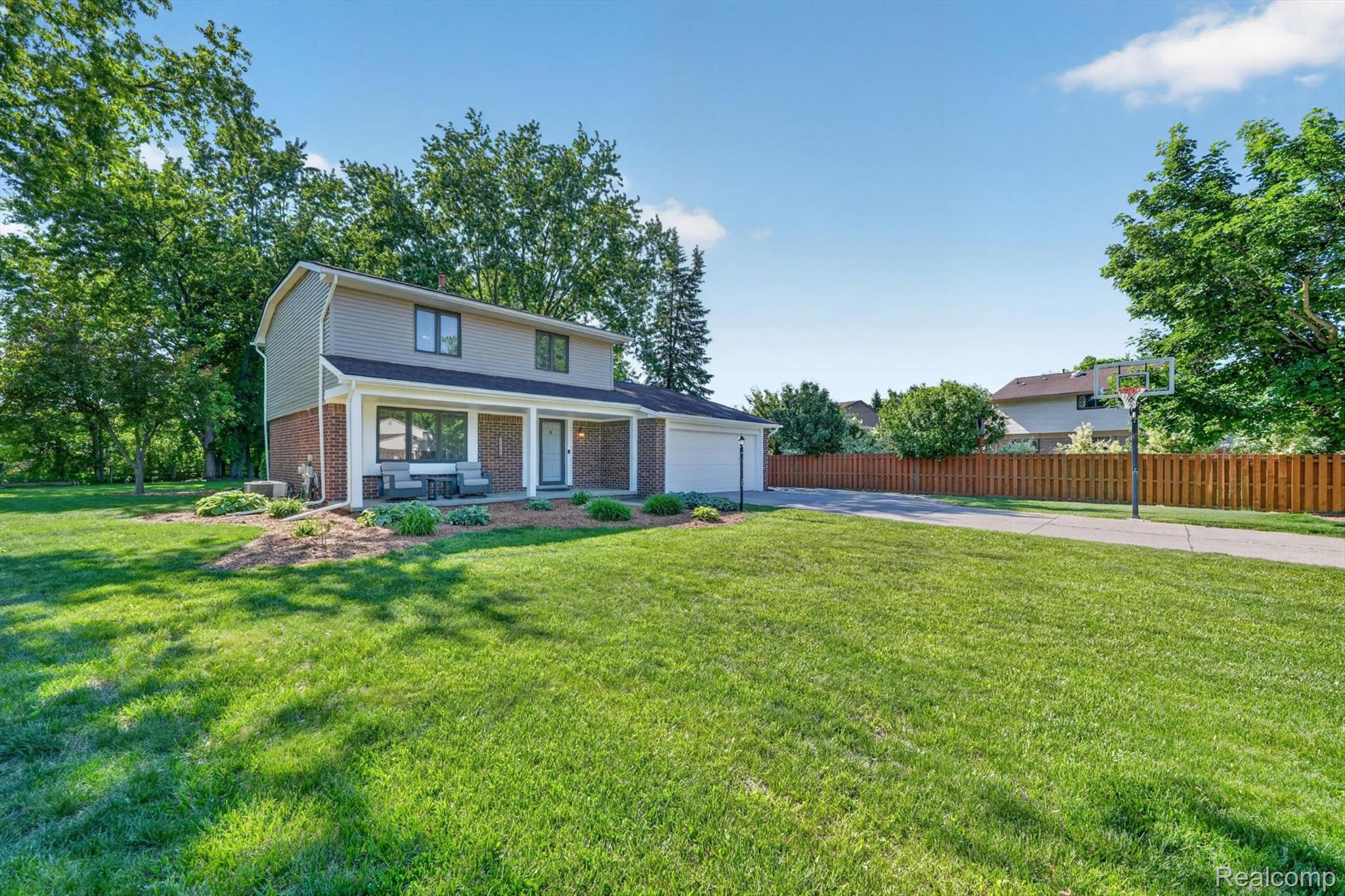 5469 Pheasant Run Road Clarkston, MI 48346 - Photo 1 of 36 Two-story residence featuring a combination of brick and siding, a covered front porch, and a paved driveway leading to an integrated garage
