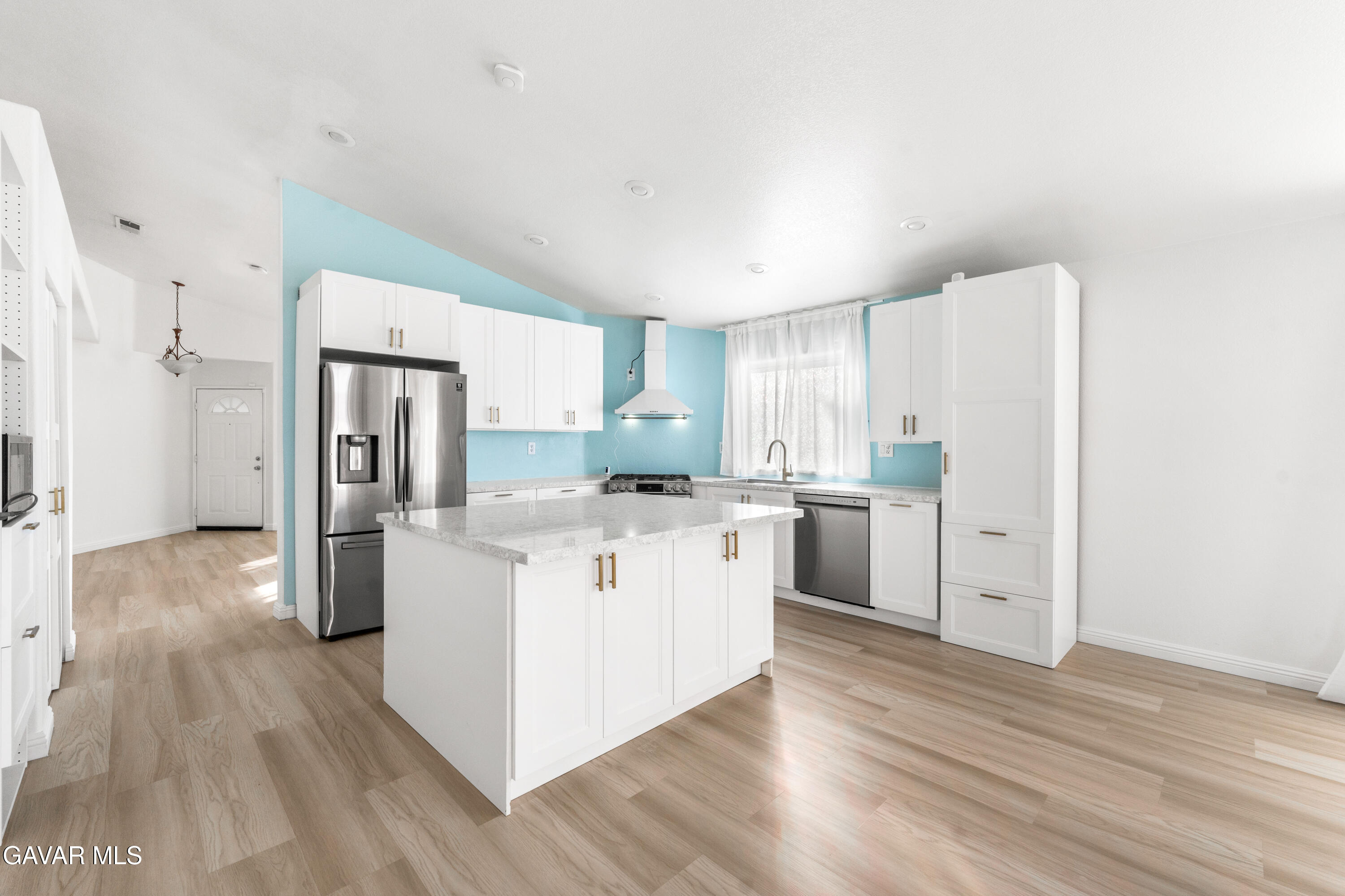 1639 East Kettering Street Lancaster, CA 93535 - Photo 13 of 35 a kitchen with stainless steel appliances a refrigerator and wooden floor