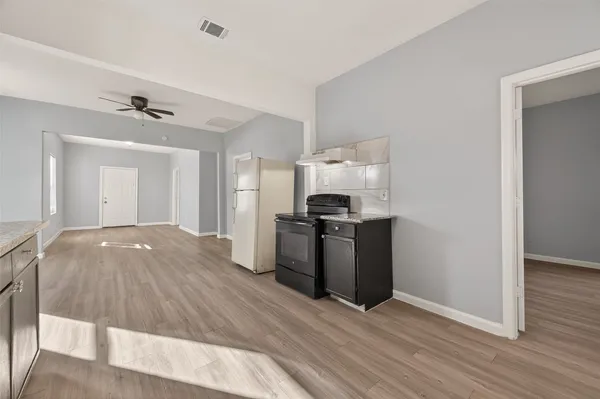 a kitchen with granite countertop a refrigerator stove and sink