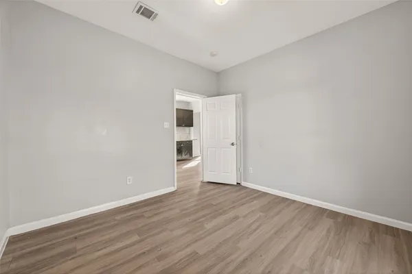 a view of an empty room with wooden floor