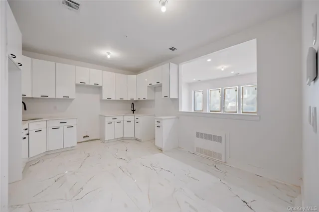 a kitchen with white cabinets and white appliances