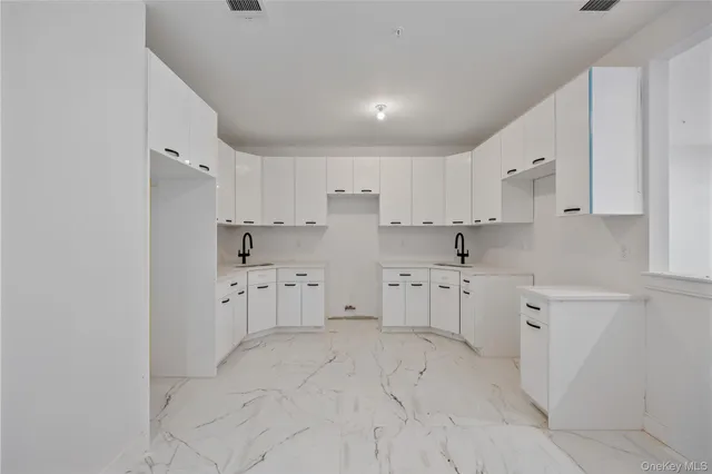 a kitchen with white cabinets and white appliances