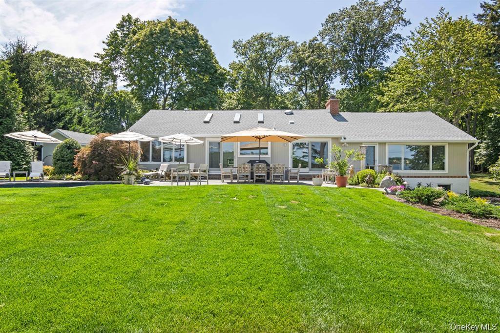88 Dyke Road Setauket, NY 11733 - Photo 48 of 49 a front view of a house with a yard table and chairs