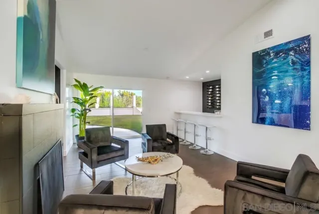 a living room with furniture a wooden floor and potted plant