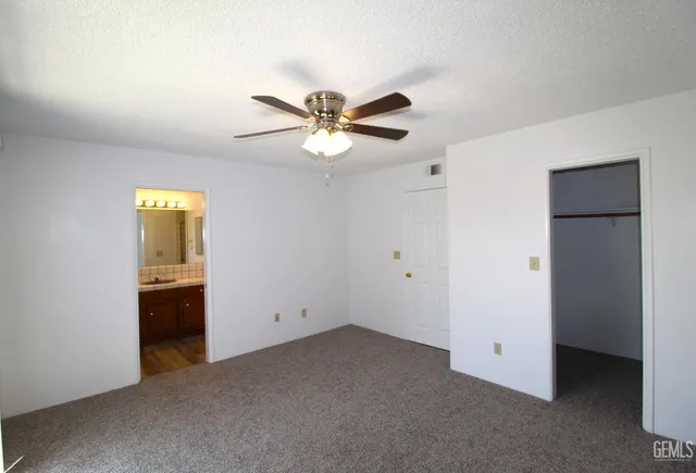 a view of an empty room with a ceiling fan and a window