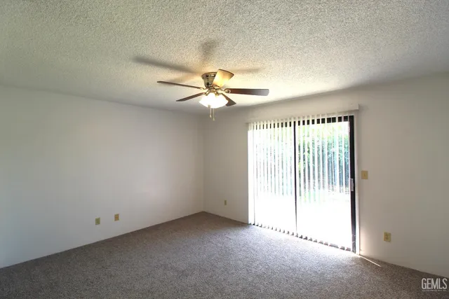 an empty room with a window and a fan