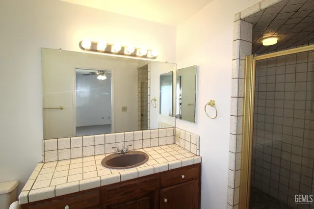 a bathroom with a granite countertop sink and a mirror