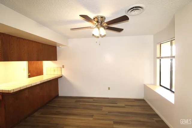 a view of an empty room with a window and a ceiling fan