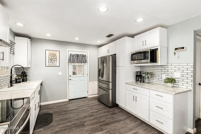 a kitchen with a sink wooden floor and stainless steel appliances