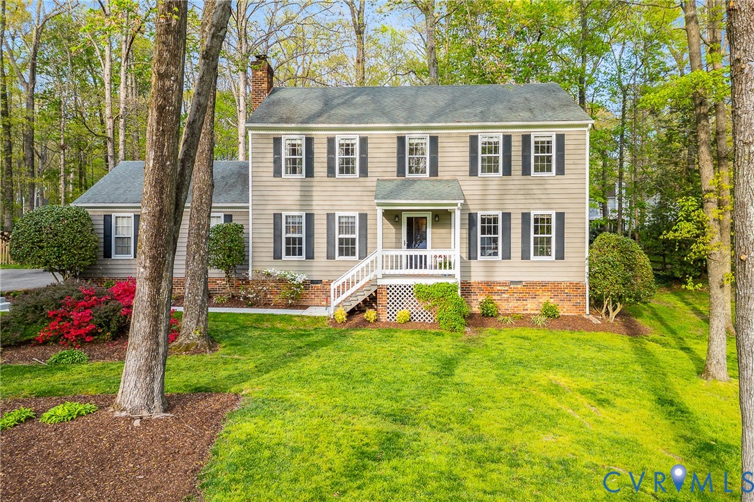 Colonial inspired home featuring a chimney, a fron