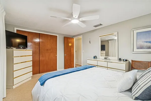 a bedroom with a bed and a large mirror