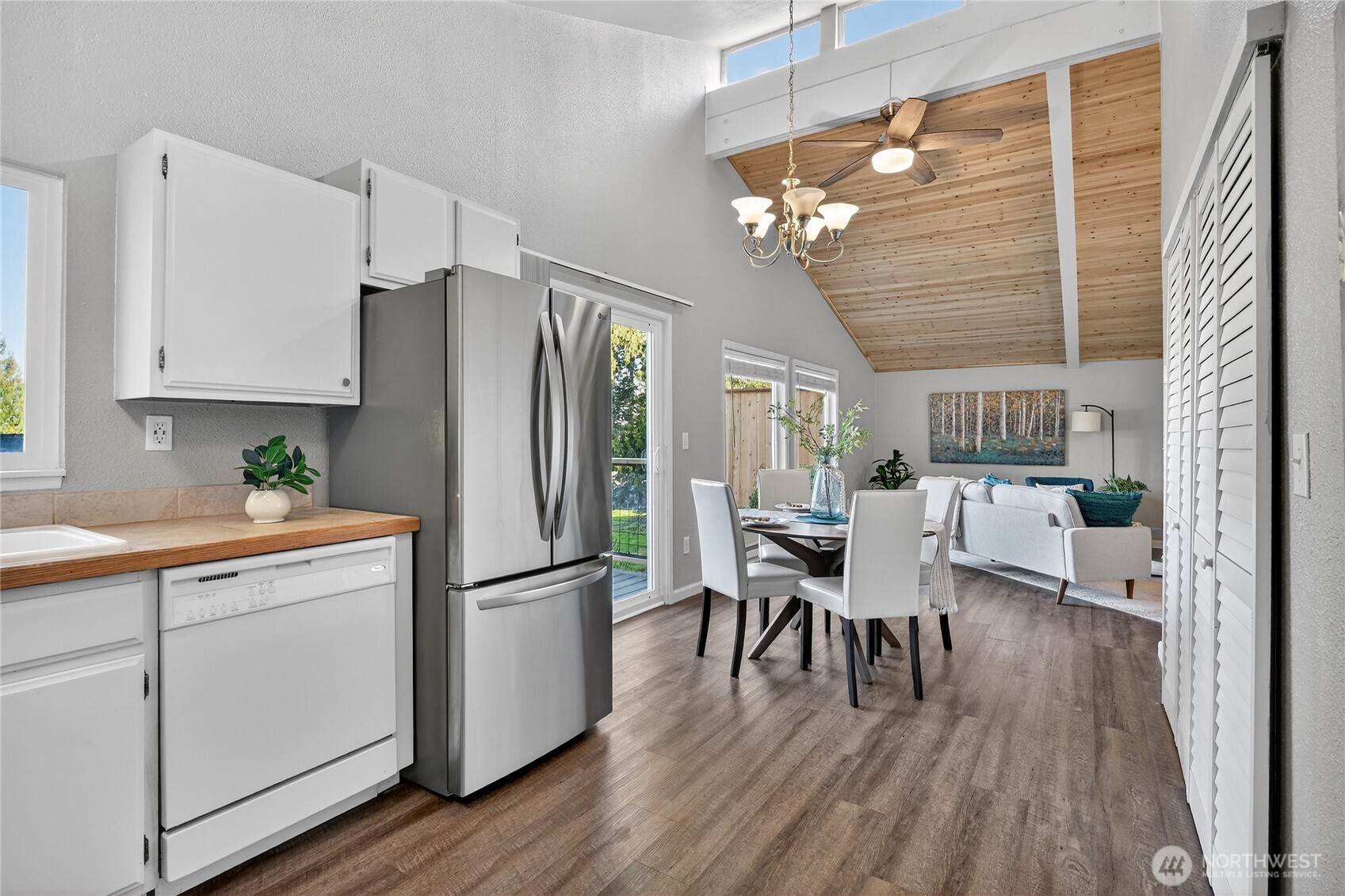 2422 McGregor Road Southeast Port Orchard, WA 98366 - Photo 11 of 32 a kitchen with stainless steel appliances granite countertop a refrigerator a microwave a dining table and chairs with wooden floor