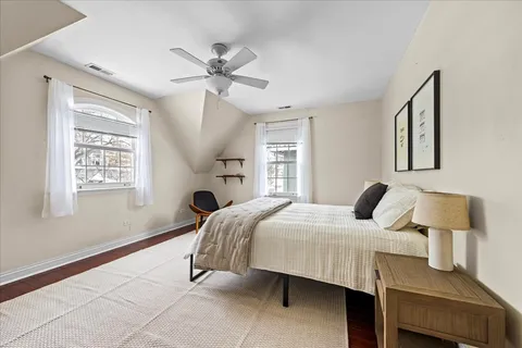 a spacious bedroom with a bed a chair and a chandelier