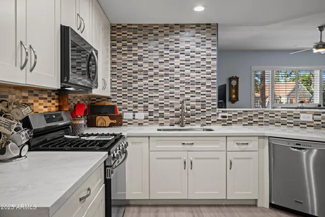 a kitchen with stainless steel appliances granite countertop a sink stove and cabinets
