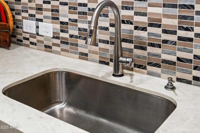 a kitchen with white cabinets and sink
