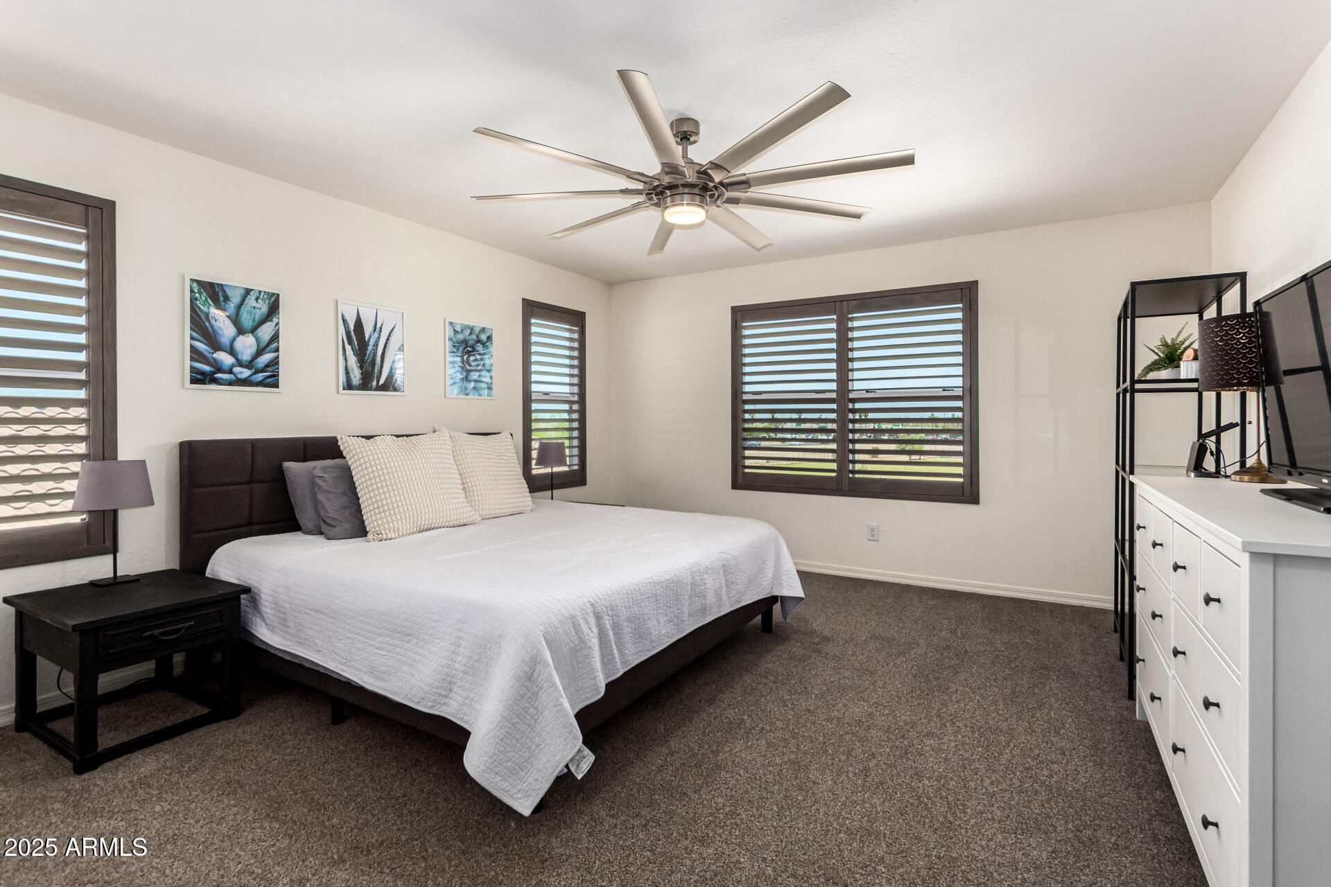820 Constance Way Phoenix, AZ 85042 - Photo 12 of 29 a spacious bedroom with a bed and a painting on the wall