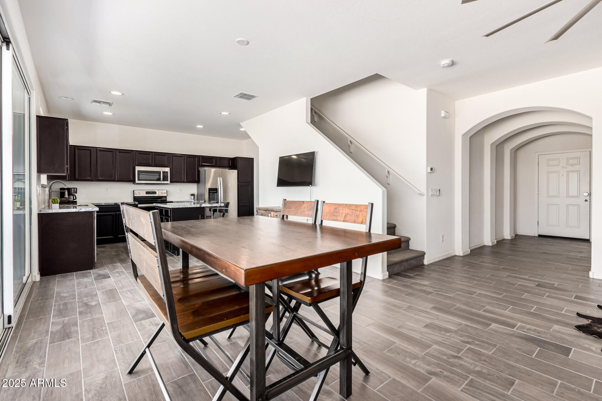820 Constance Way Phoenix, AZ 85042 - Photo 3 of 29 a kitchen with stainless steel appliances kitchen island granite countertop a table chairs and a refrigerator