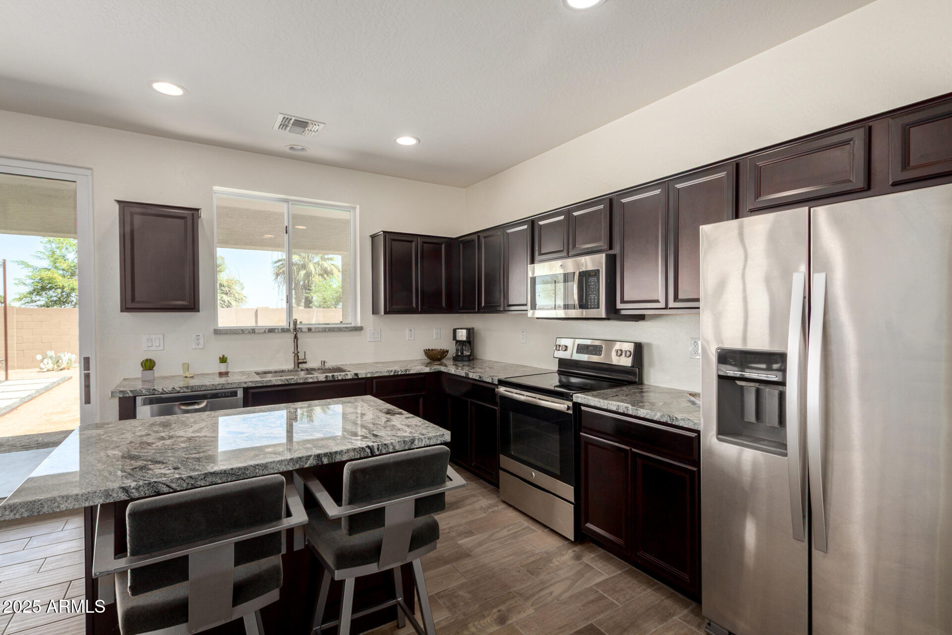 820 Constance Way Phoenix, AZ 85042 - Photo 7 of 29 a kitchen with granite countertop a refrigerator stove microwave and sink