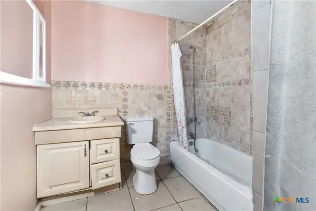 a bathroom with a granite countertop sink a toilet and shower
