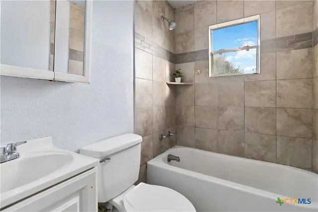 a bathroom with a toilet a sink and bathtub