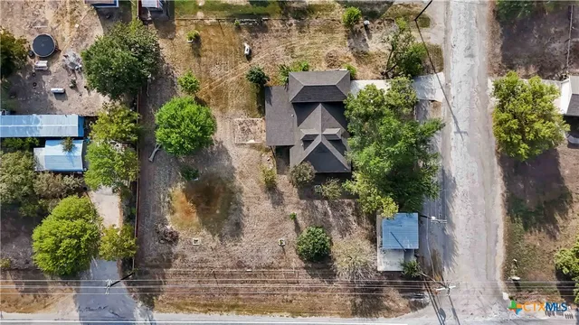an aerial view of a house with a yard and large trees