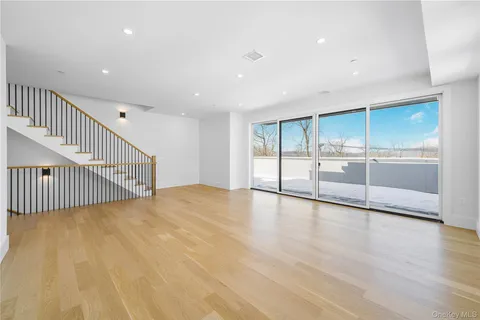 a view of an empty room with wooden floor and fence