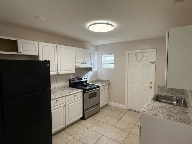 a kitchen with a sink stove and refrigerator