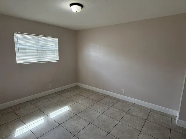 an empty room with white walls washer and dryer