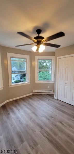 37 Delaware Avenue, Unit 2 Bloomfield, NJ 07003 - Photo 7 of 9 an empty room with wooden floor chandelier fan and windows