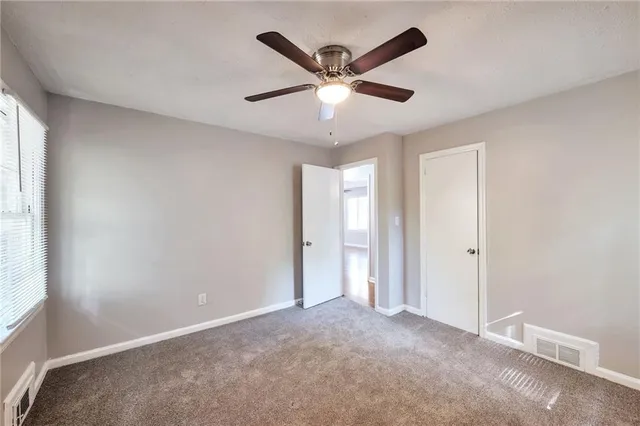a view of an empty room with a ceiling fan
