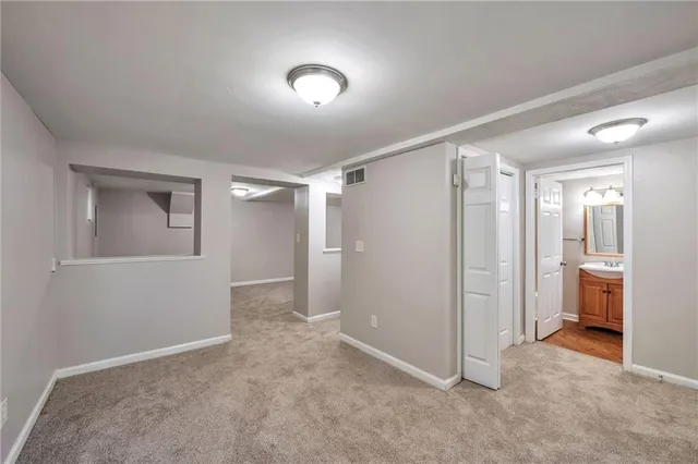 a view of a room with a walk in closet and wooden shelves