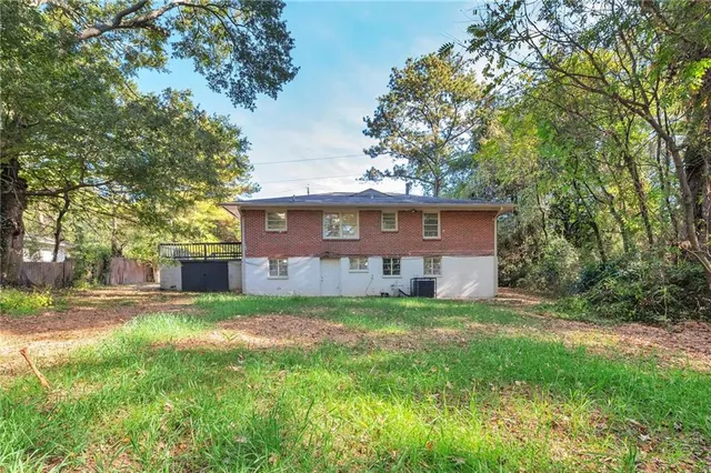 a view of a yard in front of a house with large trees