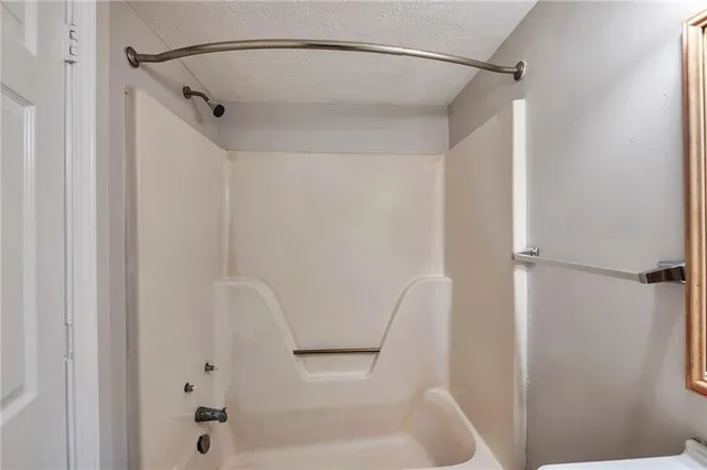 a bathroom with a shower and a bath tub