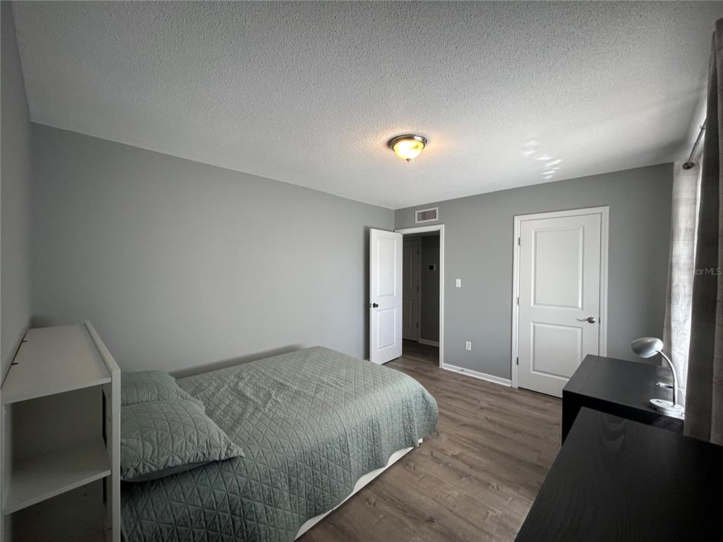 507 Northwest 39th Road, Unit 221 Gainesville, FL 32607 - Photo 11 of 19 a spacious bedroom with a bed and wooden floor