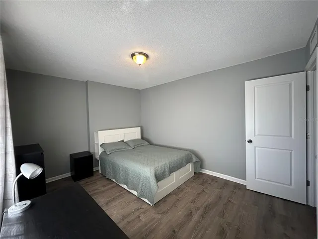 a bedroom with a bed and a lamp on desk