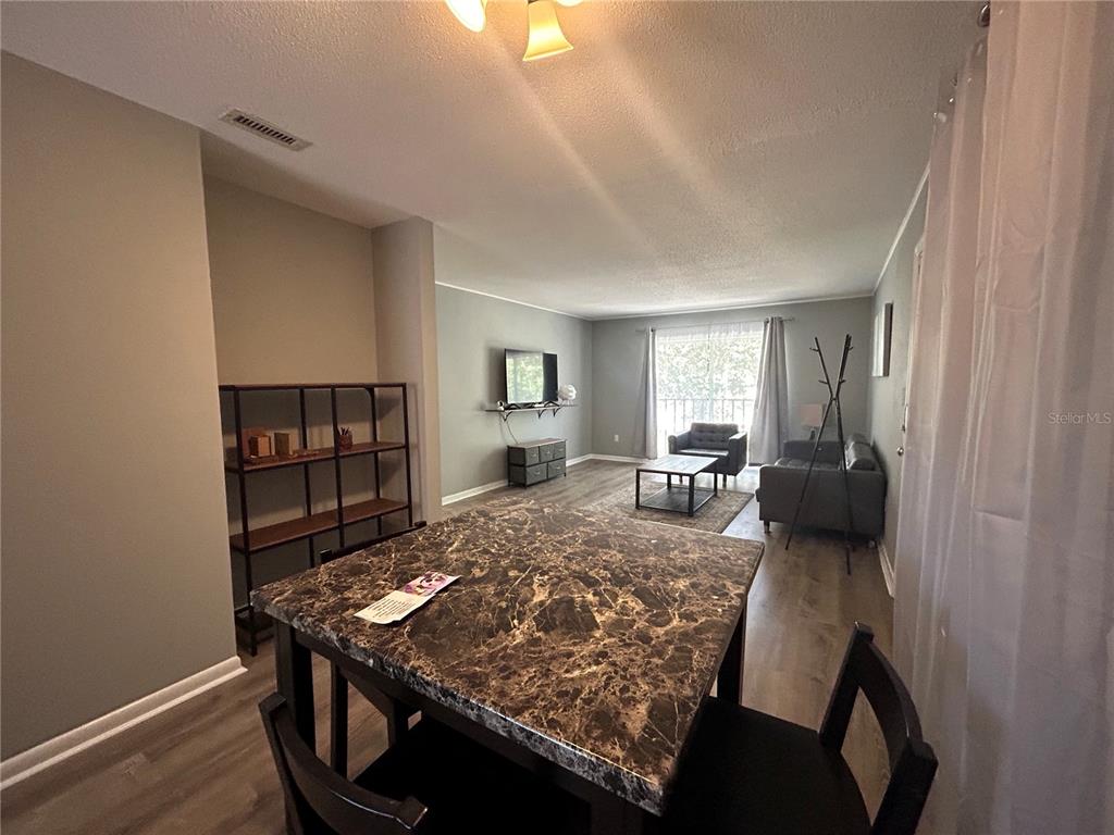 507 Northwest 39th Road, Unit 221 Gainesville, FL 32607 - Photo 14 of 19 a living room with furniture and a wooden floor