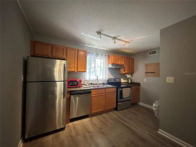 a kitchen with stainless steel appliances granite countertop a refrigerator stove a sink dishwasher and a refrigerator