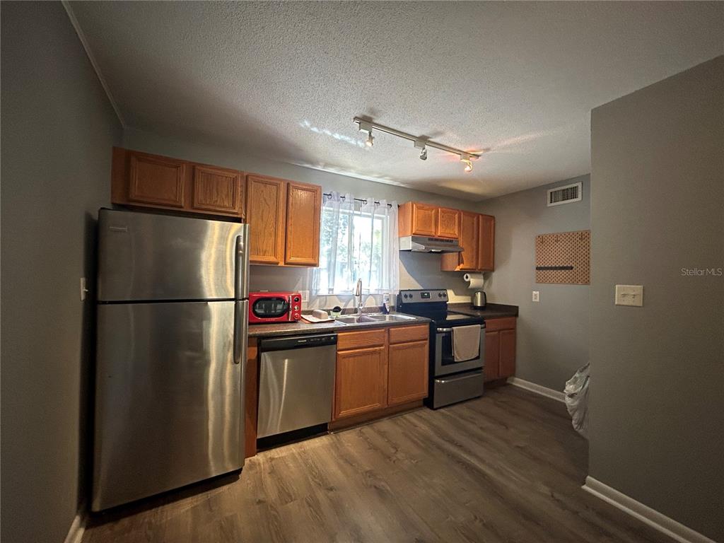 507 Northwest 39th Road, Unit 221 Gainesville, FL 32607 - Photo 17 of 19 a kitchen with stainless steel appliances granite countertop a refrigerator stove a sink dishwasher and a refrigerator